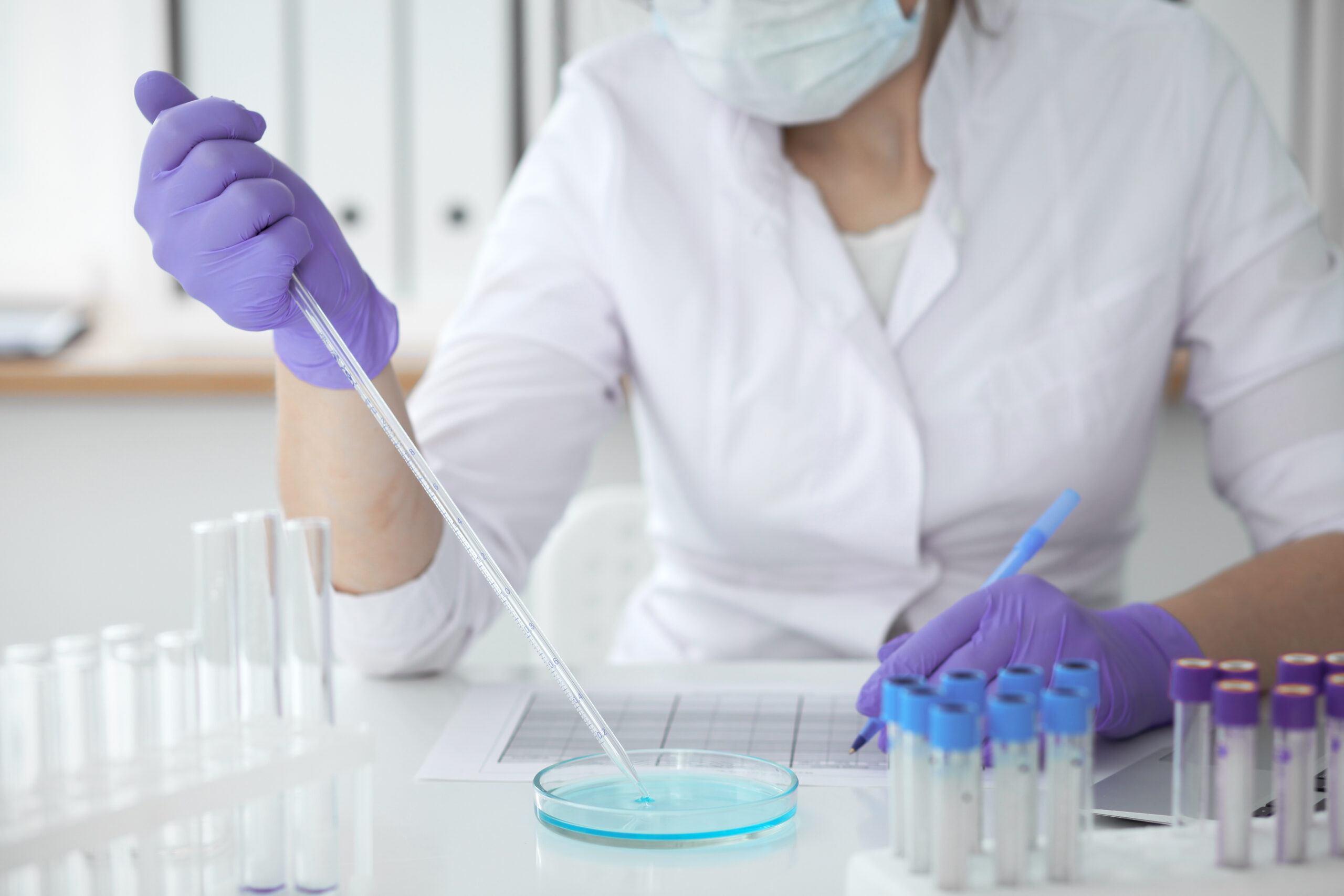 Kvinnlig forskare i laboratorium med medicinska prover – Qlooc Hälsa forskning och blodanalys